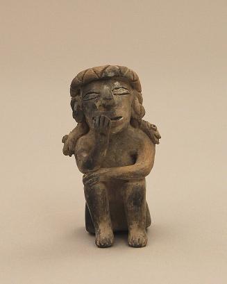 Seated figure chewing coca